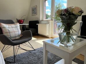 Ferienwohnung, 100m², 1-4 Pers.-Liebevoll eingerichteter Wohnbereich mit Esstisch, mehreren Stühlen und einem Fernseher