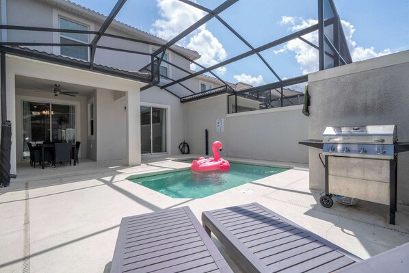 Enjoy sunny days by this private pool with a fun pink flamingo float and outdoor dining area, perfect for relaxing and entertaining!
