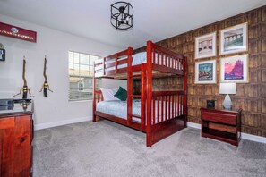 Cozy kids' bedroom with a fun Harry Potter and Harry Potter-inspired decor, featuring a sturdy bunk bed made of warm-toned wood and themed artwork on the accent wall.