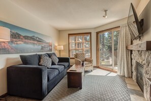 Cozy living room with comfortable seating and large windows offering nature views.