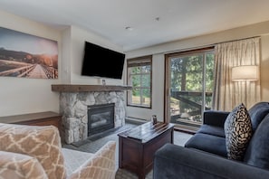 Cozy living room with a stone fireplace and a TV, perfect for relaxing.