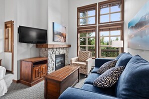 Cozy space with comfortable seating, large windows, and a TV for relaxing.