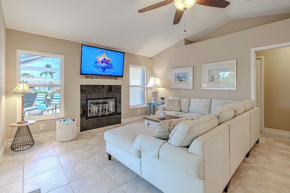 Cozy Living Room - - Unwind on the plush sectional sofa while enjoying your favorite shows on the smart TV
- Natural light pours in through large windows, enhancing the warm, inviting space
- A perfect spot for quiet evenings or lively conversations by the fireplace