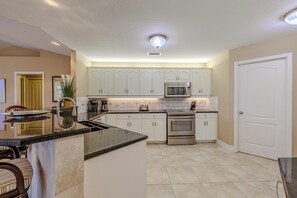 Gourmet Kitchen - - Gourmet kitchen outfitted with stainless steel appliances and pristine white cabinetry
- Open design invites conversation while cooking, with seating perfect for mingling
- Ideal for preparing meals while staying connected to the rest of the home