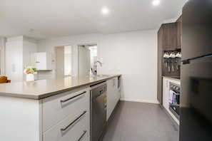 Cook with ease in the modern kitchen, featuring sleek design and high-quality appliances, fully equipped for all your culinary needs.