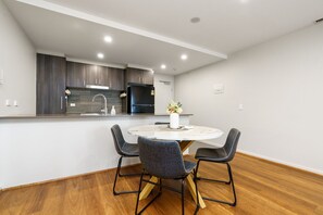 Gather around the dining table, which comfortably seats four, ideal for enjoying meals and socialising. Its stylish design enhances the dining experience and complements the modern decor of the space.