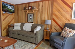 The living room has a sleeper sofa that accommodates two additional people with a 39" TV.