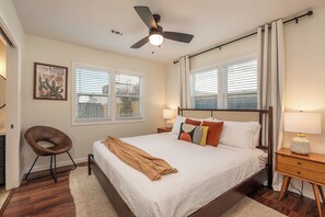 Master bedroom features a king bed, ceiling fan, blackout curtains