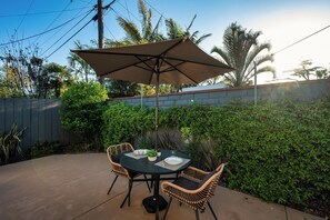 Backyard features a two seater table with umbrella