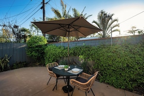Backyard features a two seater table with umbrella