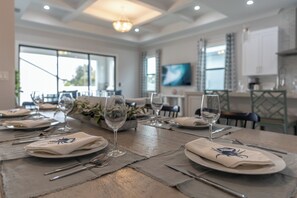 Gather around this beautiful 8-seater dining table, perfect for family feasts and fun meals with friends! Enjoy great conversations and delicious food in this inviting space! | Seaside Sanctuary, Naples, Florida | Voyax Luxury Vacation Rentals