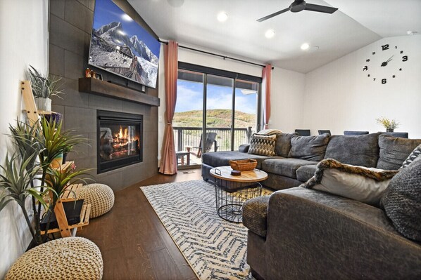 A welcoming living room featuring a cozy sofa, a fireplace, and a large flat-screen TV for ultimate comfort and relaxation.