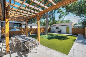 Enjoy outdoor dining under the pergola in the spacious backyard.