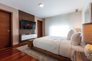 Spacious main room with a queen bed, private bathroom, walk-in closet, smart TV, and a balcony with a stunning view.