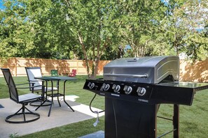 Backyard with table, chairs, and grill!