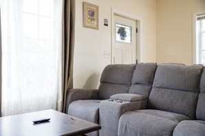 Cozy living room with comfy seating and smart TV — perfect for unwinding.
