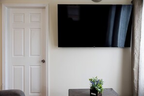 Cozy living room with comfy seating and smart TV — perfect for unwinding.