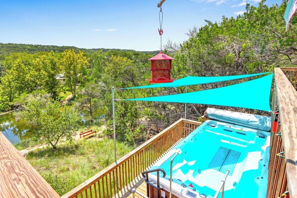Oversized hot tub with shade that overlooks the Hill Country