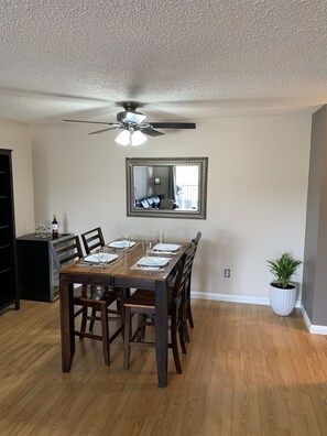 Spacious dining room with large table. Place setting for 4 guests.