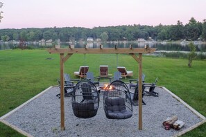 Unwind by the fire pit with cozy seating and breathtaking lake views at dusk.