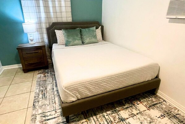 Rest in comfort on a queen-size bed with plush linens and thoughtful touches, designed for a peaceful night's sleep