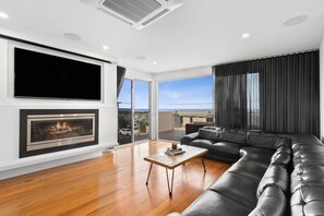 Enjoy a state-of-the-art entertainment setup with Smart TV, a projector for movie nights, and a cosy gas log fire