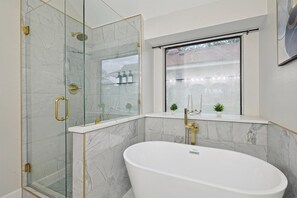 Primary bathroom equipped with a gorgeous bathtub to relax in as well as a spacious shower
