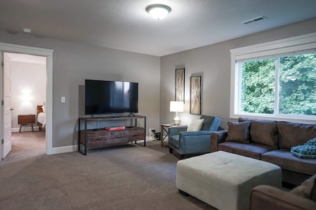 Bright & Spacious Living Room – Kick back and stream your favorites with tree views and cozy seating.