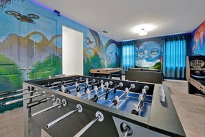 Dive into the action in this fully equipped game room, featuring foosball, arcade games, and custom themed murals.