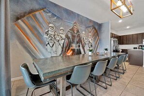 Gather around the large dining table in this fun Star Wars-themed dining area, perfect for family meals and entertaining.