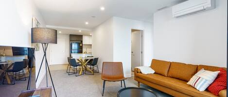 Relax in the modern, stylish living room featuring a leather lounge and smart TV, creating the perfect space for entertainment and comfort.