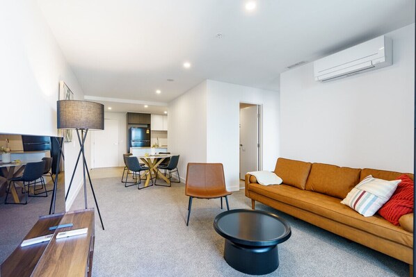 Relax in the modern, stylish living room featuring a leather lounge and smart TV, creating the perfect space for entertainment and comfort.