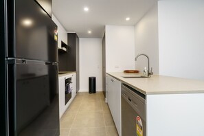 Cook with ease in the modern kitchen, fully equipped with appliances and an induction stove, offering both style and functionality for your culinary needs.