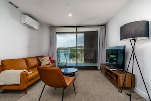 Relax in the modern, stylish living room featuring a leather lounge and smart TV, creating the perfect space for entertainment and comfort.