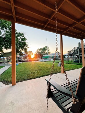 Swing bench overlooking a stunning sunset, the perfect spot to unwind.