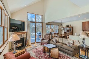 Living room with flat screen TV, gas fireplace, and patio access