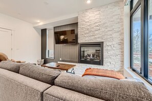Open living space with gas fireplace, sofa sleeper, and Smart TV