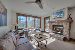 Living room with sofa sleeper, Smart TV, gas fireplace, balcony access