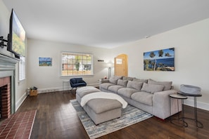 Living room with extremely big, comfy couch and smart television.