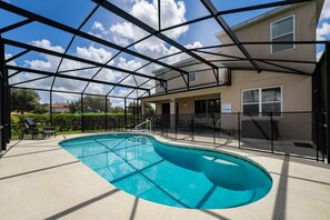 Pool view showing screened enclosure and child safety fence