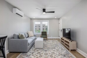 The living room features a sleeper sofa and a flat-screen TV.