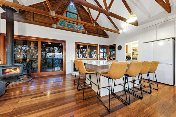 Cozy up by the fire and enjoy modern comfort with stunning architectural details in this inviting kitchen space.