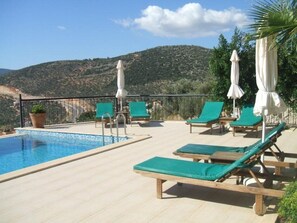 Spacious patio area with sunbeds and umbrellas