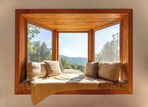 Cozy cushioned built-in with peaceful mountain scenery.