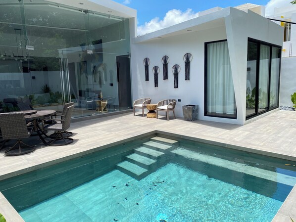 view of the outdoor pool, outdoor dining and patio, and principal bedroom
