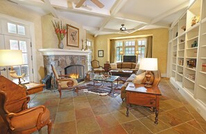 Living Room with wood burning fireplace, 2 sets of doors out to the veranda