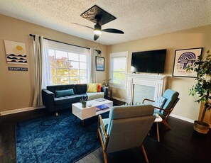 Living room space with comfortable seating, 58" smart TV and electric candles