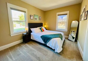 The Palms Bedroom with Queen bed, view into the private backyard, hypoallergenic (feather-free) duvet and pillows,  and blanket.