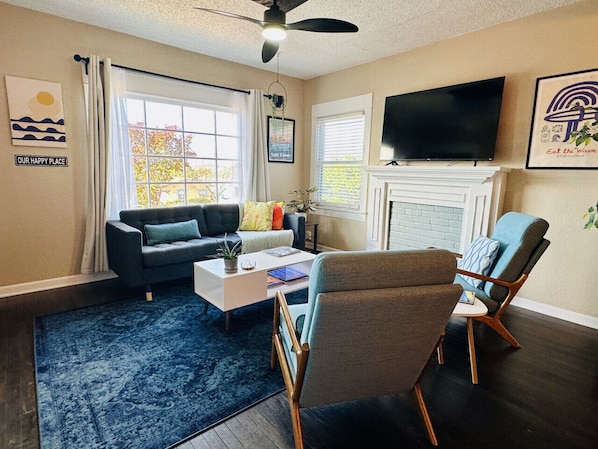 Living room space with comfortable seating, 58" smart TV and electric candles