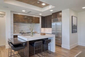 Fully equipped kitchen with a gas range and barstool seating.